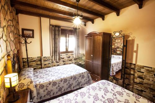 a bedroom with two beds and a cabinet and a window at Alojamientos Rurales Benarum con Spa in Alpujarra De La Sierra