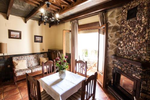 a dining room with a table and a fireplace at Alojamientos Rurales Benarum con Spa in Alpujarra De La Sierra