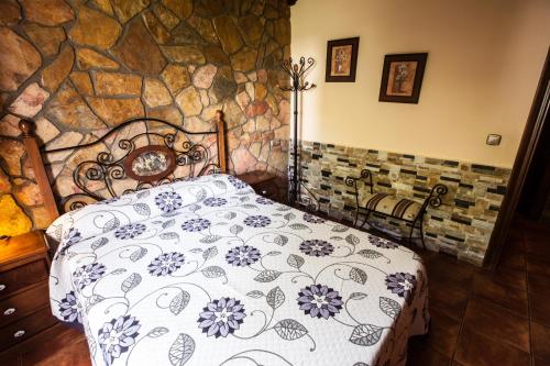 a bedroom with a bed with a stone wall at Alojamientos Rurales Benarum con Spa in Alpujarra De La Sierra