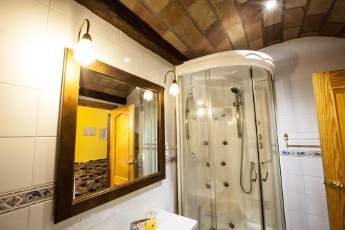 a bathroom with a shower and a sink and a mirror at Alojamientos Rurales Benarum con Spa in Alpujarra De La Sierra