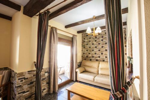 a living room with a couch and a window at Alojamientos Rurales Benarum con Spa in Alpujarra De La Sierra