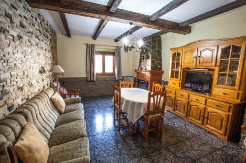 a living room with a couch a table and a tv at Alojamientos Rurales Benarum con Spa in Alpujarra De La Sierra