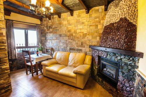 a living room with a couch and a fireplace at Alojamientos Rurales Benarum con Spa in Alpujarra De La Sierra