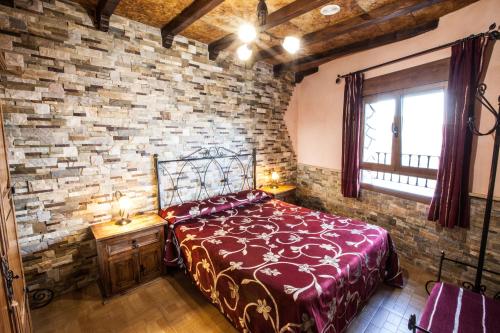 a bedroom with a brick wall with a bed and a window at Alojamientos Rurales Benarum con Spa in Alpujarra De La Sierra