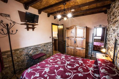 a bedroom with a red bed in a room at Alojamientos Rurales Benarum con Spa in Alpujarra De La Sierra