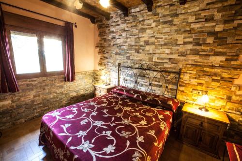 a bedroom with a bed and a brick wall at Alojamientos Rurales Benarum con Spa in Alpujarra De La Sierra