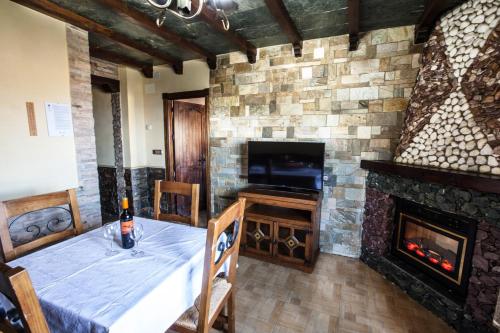 a room with a fireplace and a table and a television at Alojamientos Rurales Benarum con Spa in Alpujarra De La Sierra