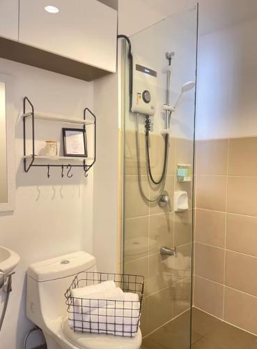 a bathroom with a glass shower and a toilet at The Suite Pod I CDO CondoStaycation - U26 in Cagayan de Oro