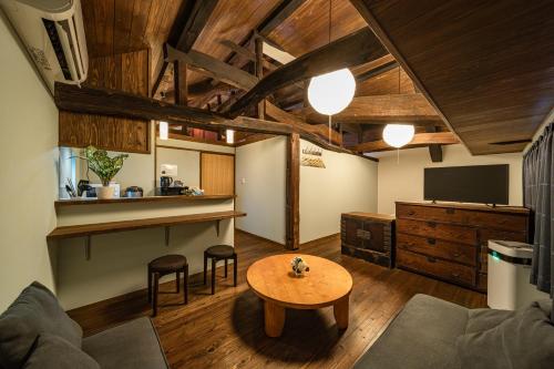 a living room with a table and a tv at 油屋別邸 in Beppu