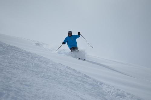 a man is skiing down a snow covered slope at Hotel Surselva in Surcuolm