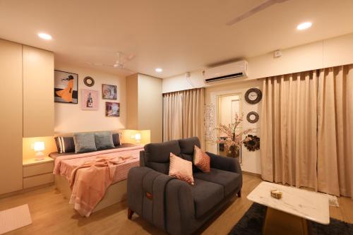 a bedroom with a bed and a couch at BlancHaus Stays - Premium Luxury I Viman Nagar I Near Pune Airport I Skyline View in Pune