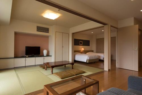 a bedroom with a bed and a living room at Scenery Resort Suruga in Numazu