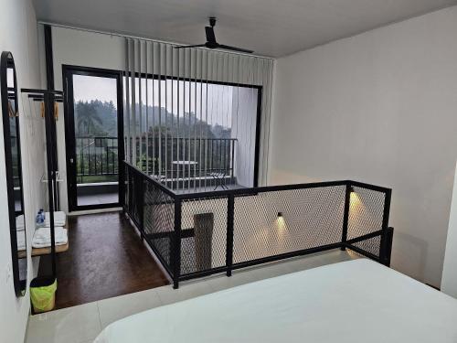 a bedroom with a bed and a large window at Naava Village in Tagalbato