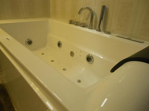 uma banheira branca com uma torneira na casa de banho em Atocha Palace em Madri