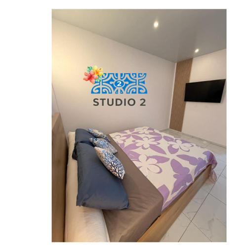 a bedroom with a bed and a sign on the wall at Kahaia stay lodge in Papeete