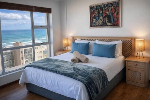 a bedroom with a bed with a view of the ocean at Ocean View B1001, Blouberg in Bloubergstrand
