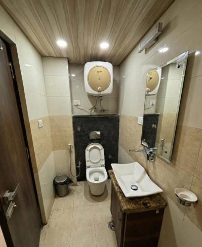 a small bathroom with a toilet and a sink at Golden Glow Stays in Shimla