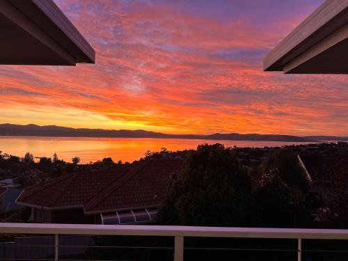 a sunset from the balcony of a house at Hobart Bay Sunrise House--Rare Aurora Viewing Opportunities in Hobart