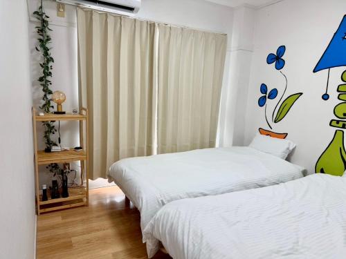 a bedroom with two beds and a window at mkh room TAKAMATSU in Takamatsu