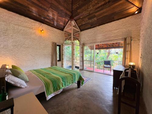 a bedroom with a bed and a large window at T Stop Farmhouse Coorg in Kurchi