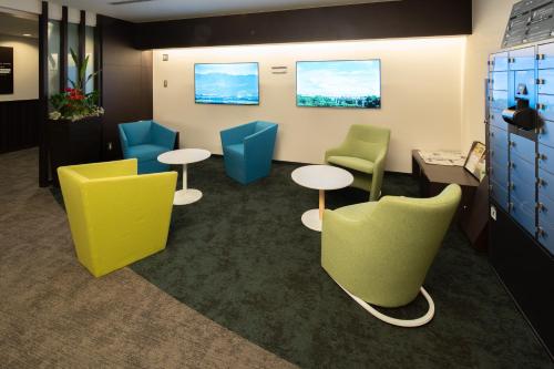 a waiting room with colorful chairs and tables at Osaka Airterminal Hotel in Toyonaka