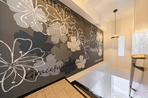 a hallway with a wall mural of flowers at Matcha Inn Sakura Tokyo in Tokyo