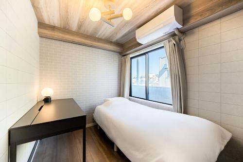a small bedroom with a bed and a window at Matcha Inn Sakura Tokyo in Tokyo