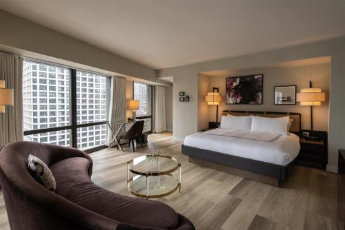 a hotel room with a bed and a couch at Thompson Chicago, by Hyatt in Chicago