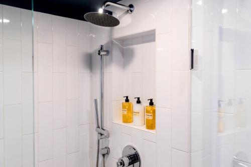 a bathroom with a shower with bottles on a shelf at Thompson Chicago, by Hyatt in Chicago