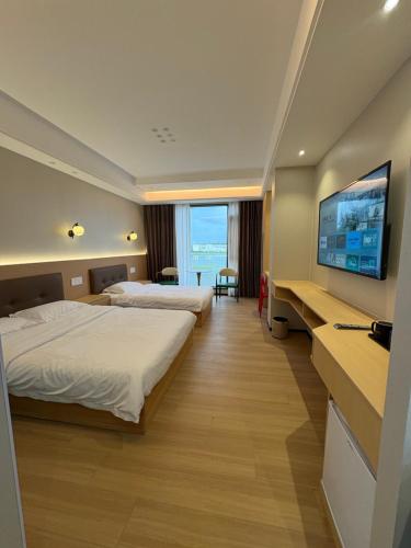 une chambre d'hôtel avec deux lits et une télévision à écran plat dans l'établissement Fantasy Inn, à Nuku‘alofa