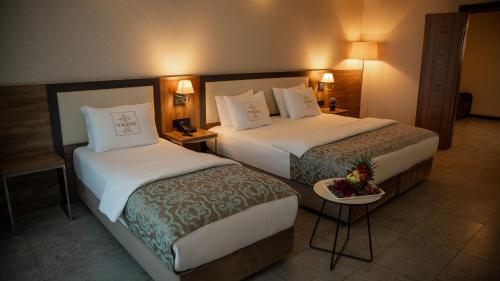 a hotel room with two beds and a table at Yildiz Life Hotel in Trabzon