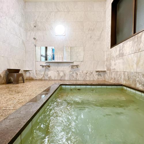 a bathroom with a large pool of water at Chouchinya in Nozawa Onsen