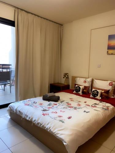 a bedroom with a large bed with flowers on it at Larnaca Beach Apartment in Larnaca