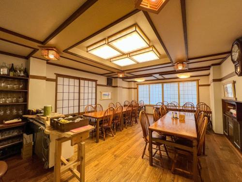 a dining room with wooden tables and chairs at Chouchinya in Nozawa Onsen
