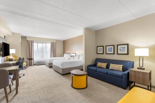 Comfort Suites Near Universal Orlando Resort tesisinde bir odada yatak veya yataklar