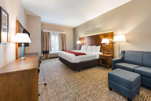 a large hotel room with a bed and a couch at Comfort Inn Grove City - Columbus South in Grove City