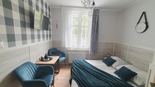 a bedroom with a bed and two chairs and a window at Willa Azur blisko plaży, centrum Mielna in Mielno