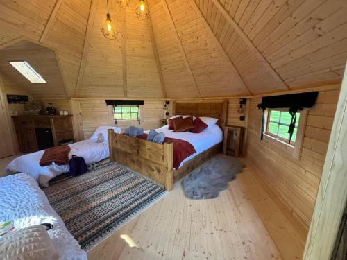 a bedroom with two beds in a wooden house at Press Brook Park in Clay Cross