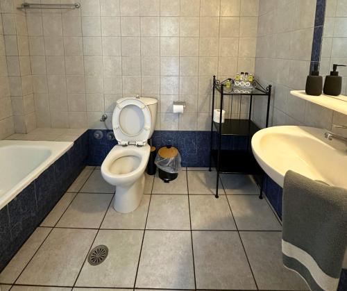 a bathroom with a toilet and a tub and a sink at Irigeneia Hotel in Perissa