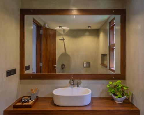 a bathroom with a sink and a large mirror at Avora Lake Villas in Anuradhapura