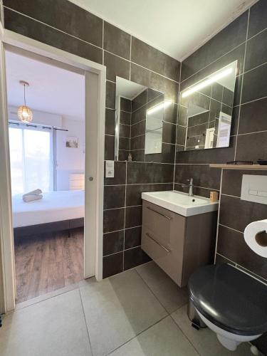 a bathroom with a toilet and a sink and a tub at Appartement 200m plage Dinard in Dinard