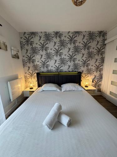 a bedroom with a bed with two towels on it at Appartement 200m plage Dinard in Dinard