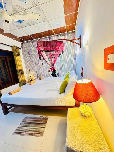 a bedroom with a large bed and a red lamp at Freedom Cottage & Safari in Tissamaharama