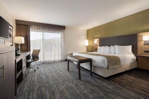 a hotel room with a large bed and a desk at The Kendrick Hotel, an Ascend Collection Hotel in Flagstaff