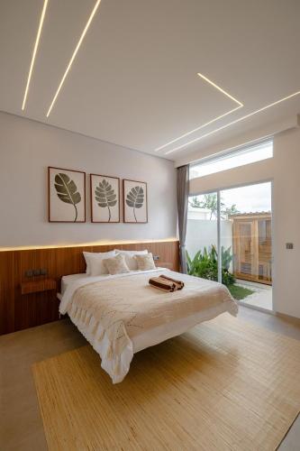 a bedroom with a large bed and a large window at Nyaman lima Villas in Canggu