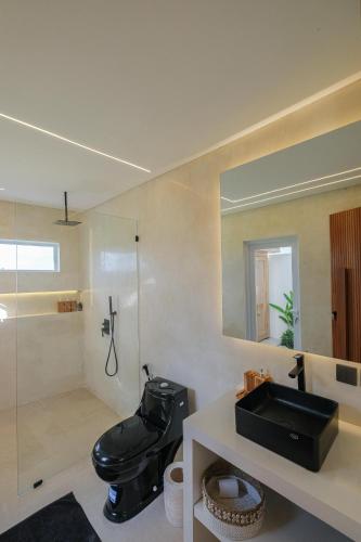 a bathroom with a black toilet and a sink at Nyaman lima Villas in Canggu