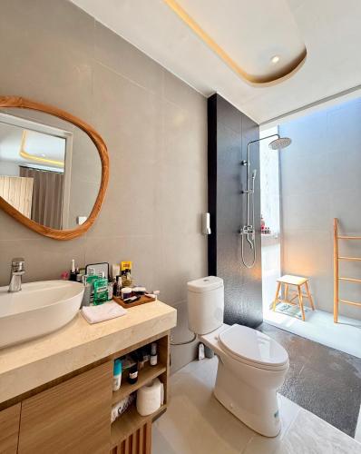 a bathroom with a toilet and a sink and a shower at Villa Lipa in Ungasan