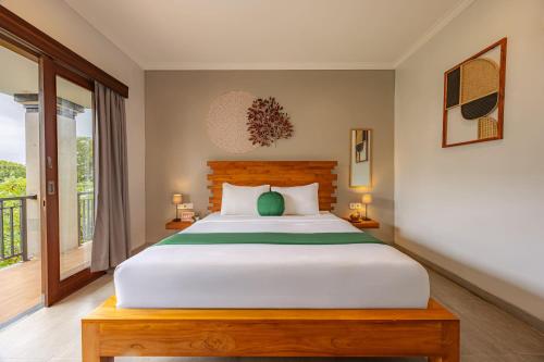 a bedroom with a large white bed and a window at Cove Ayuna in Canggu