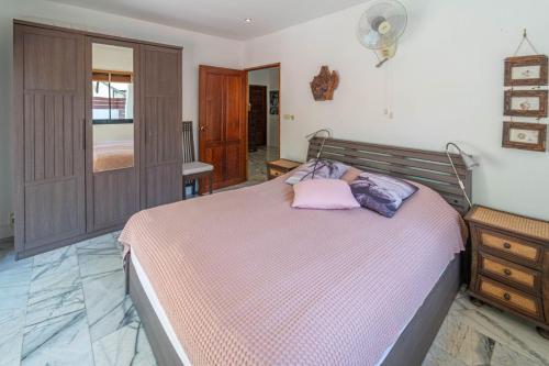 a bedroom with a bed with a pink pillow on it at Malee Beach C6 in Phra Ae beach