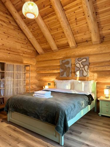 a bedroom with a bed in a wooden cabin at Sparrow's Nest Spacious Mountain Chalet with Hot Tub and Panoramic Views in Râşnov